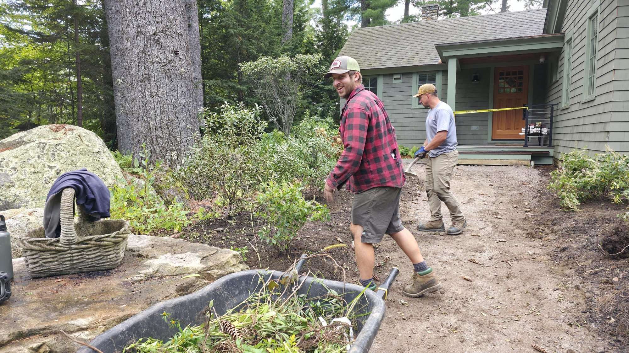 Two of the Cape Landscapes crew planting shrubs beside a house