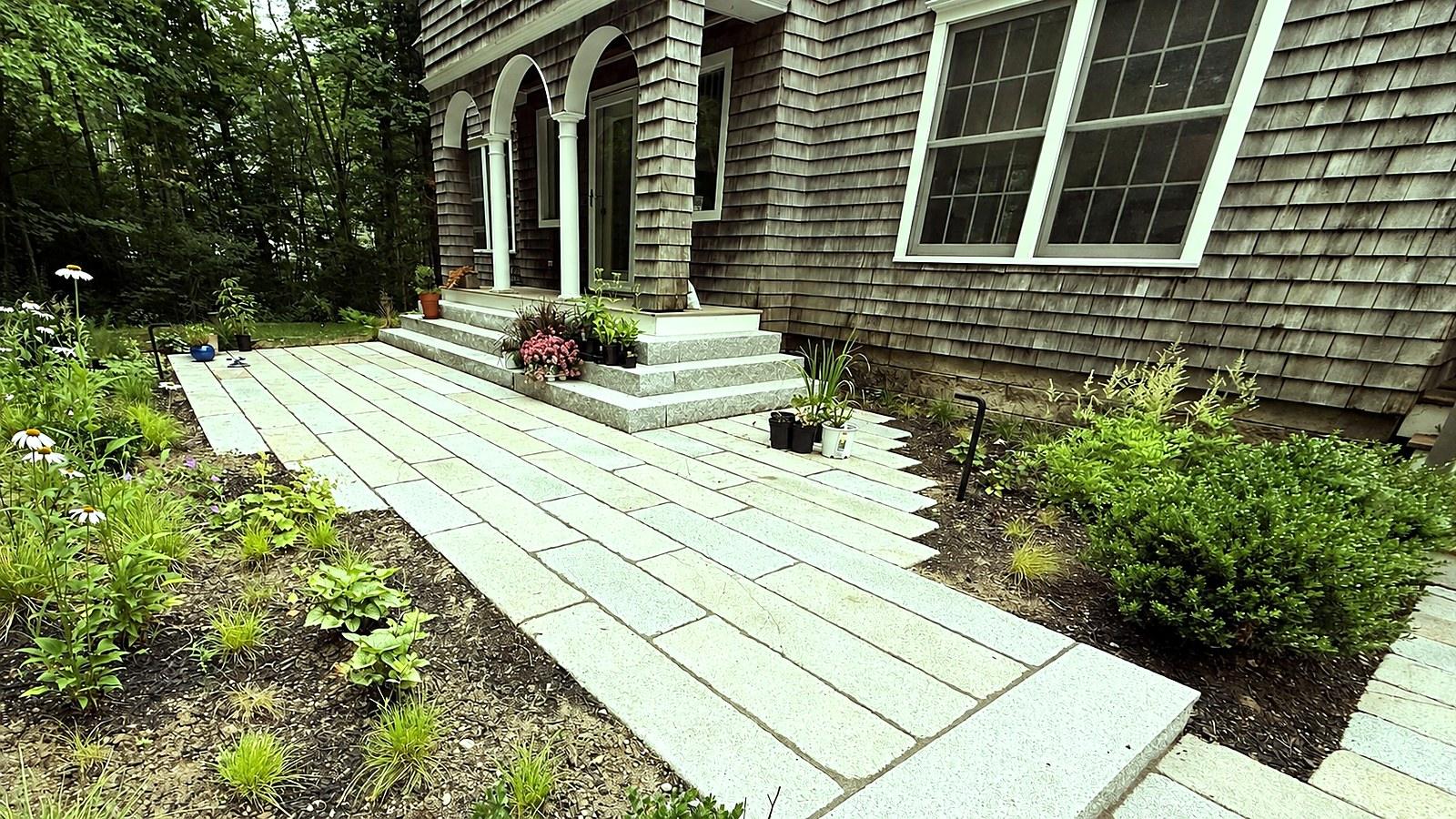 Granite steps and walkway to a shingled house entry