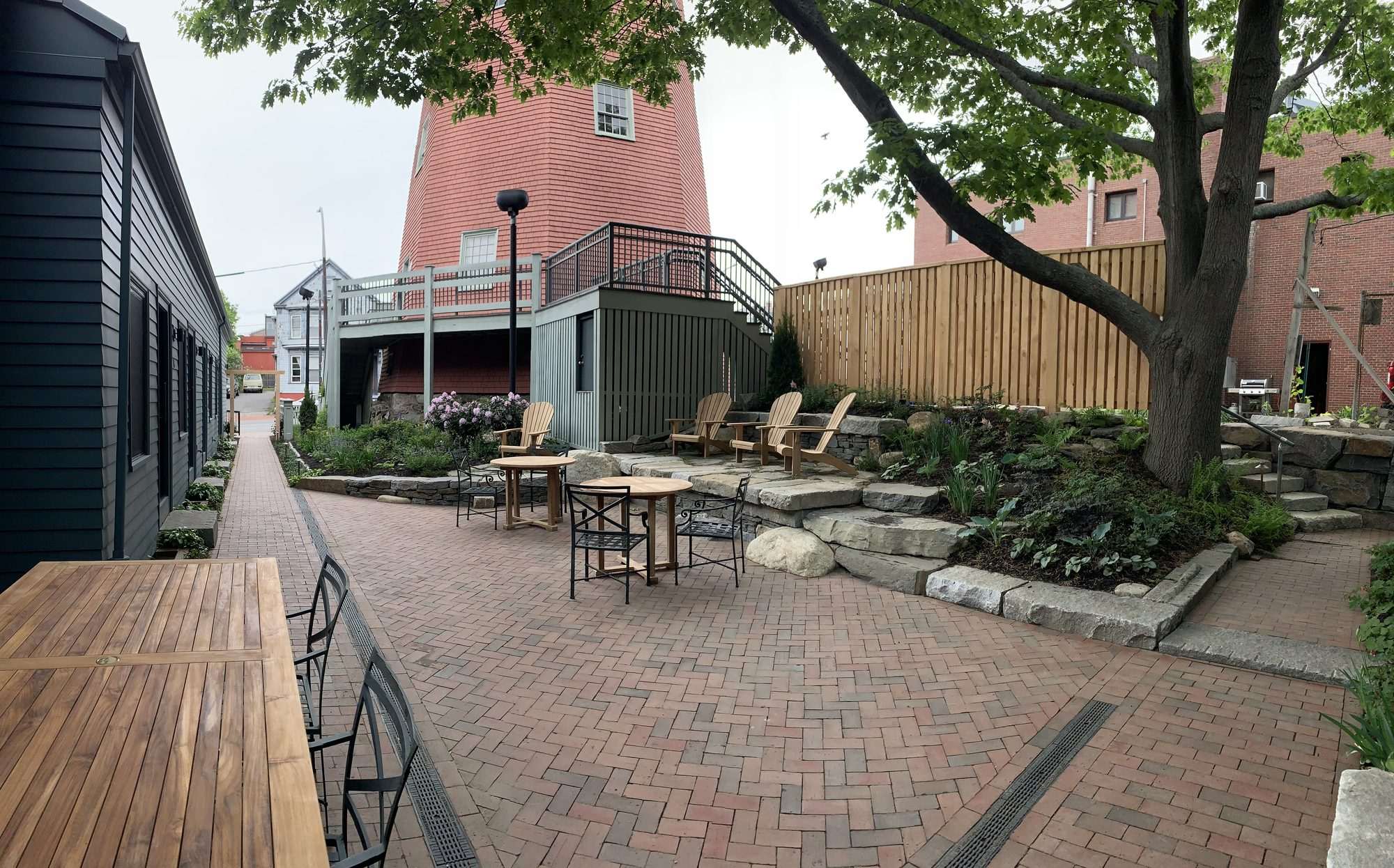Wide view of the Best Bower Hotel courtyard with brick patio, stone terracing, and the tower building