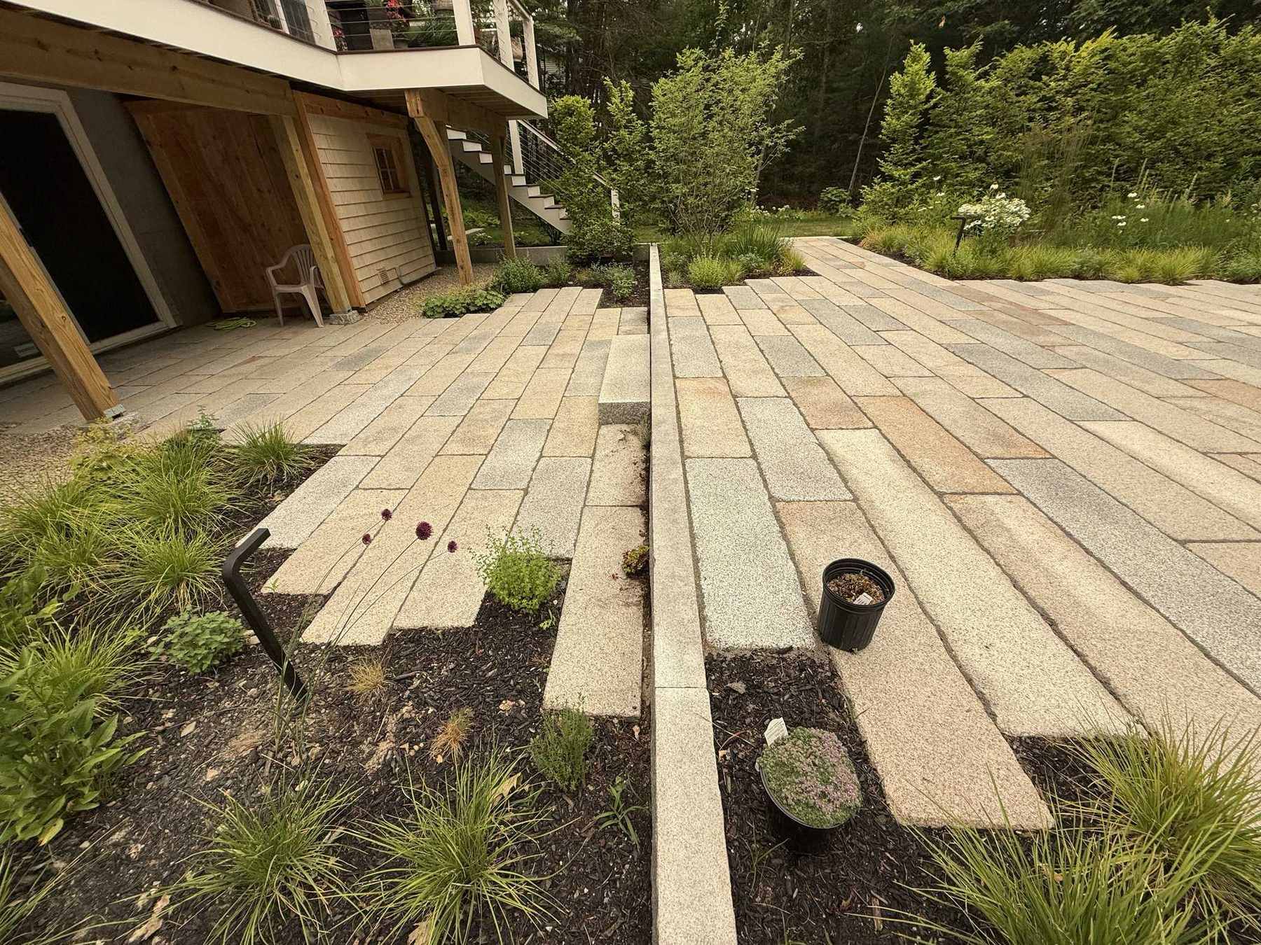 Main patio with granite retaining wall and meadow behind