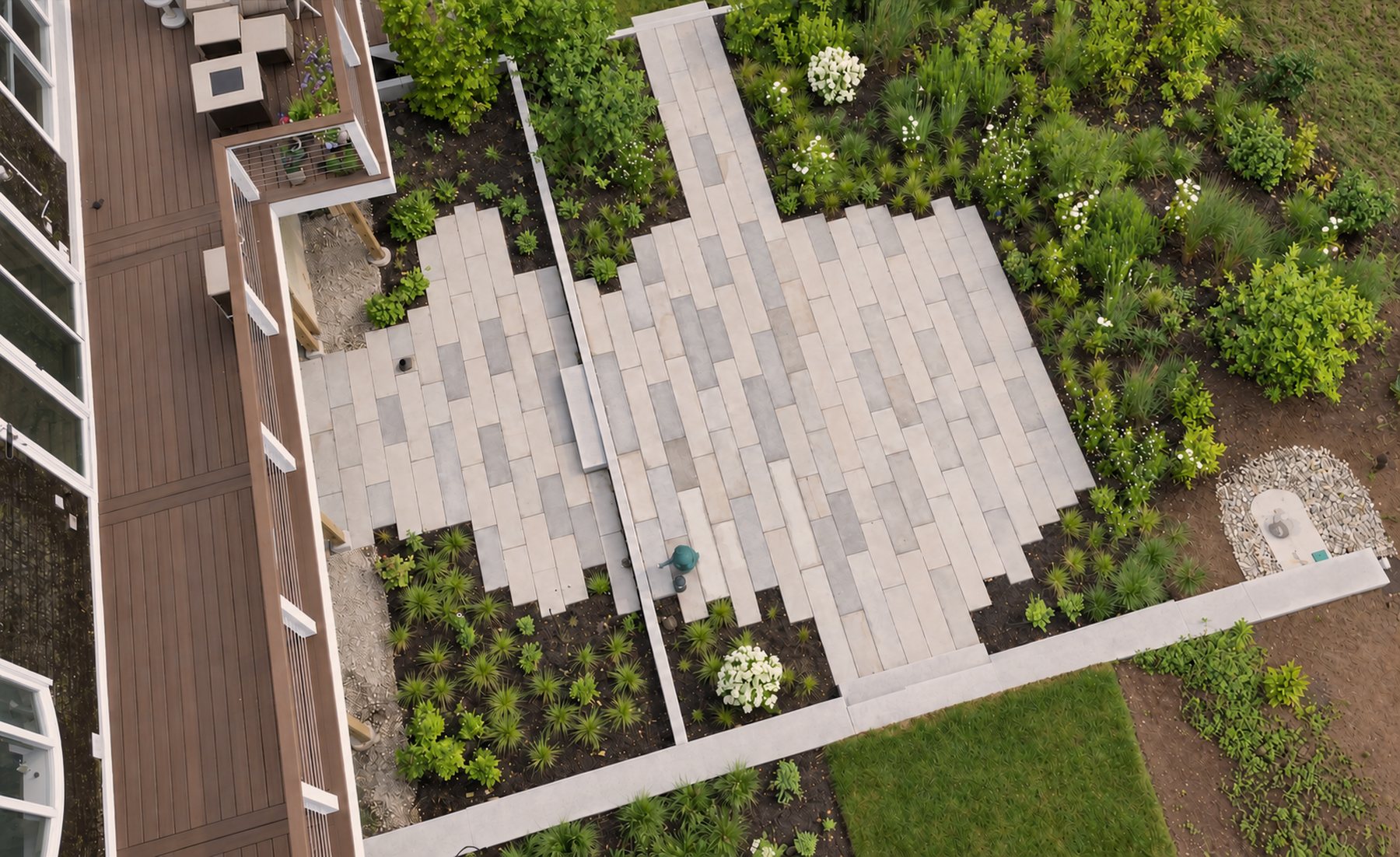 Aerial view of a granite plank patio with plantings beside a deck