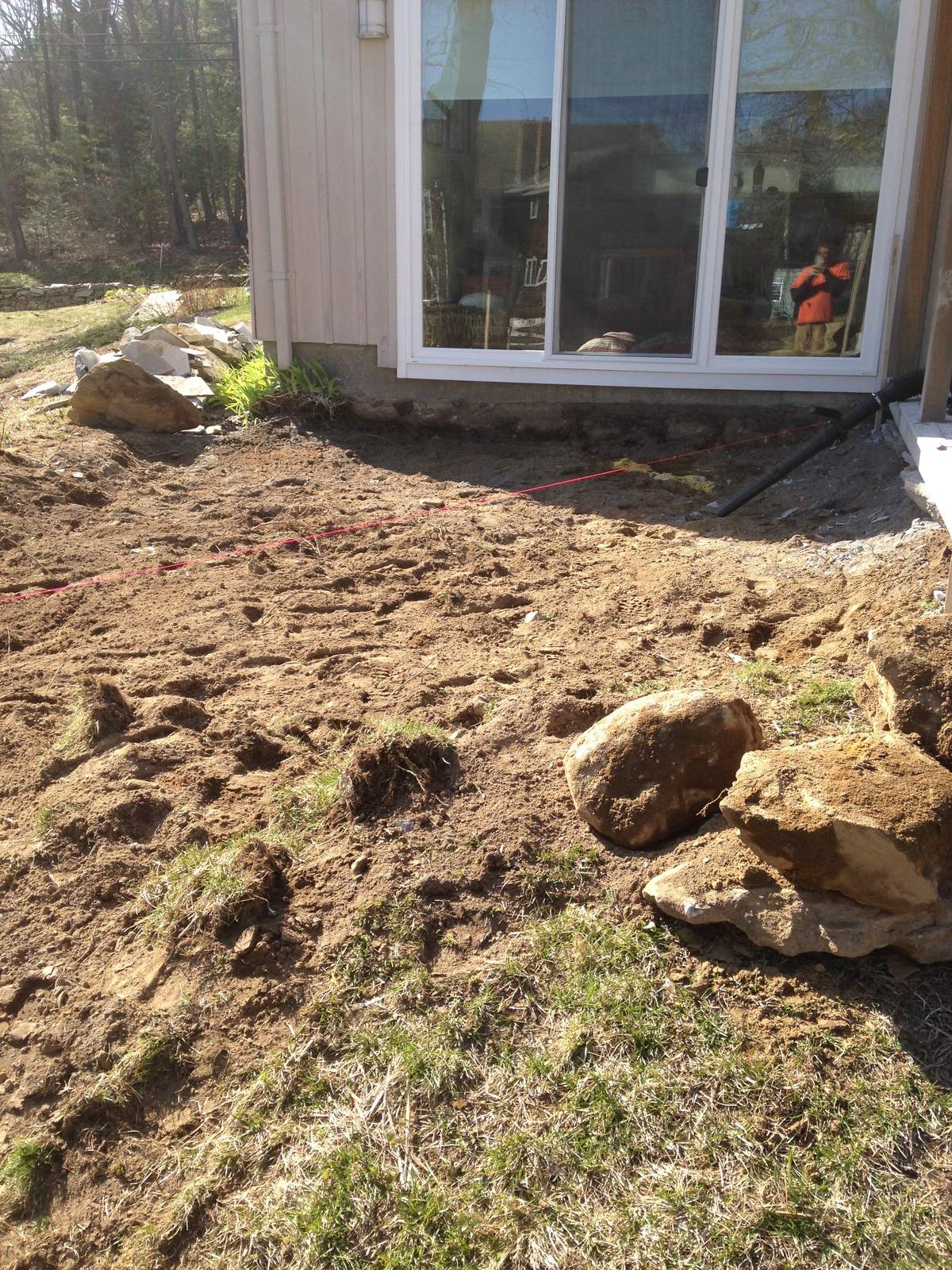 Yard excavated along the house foundation before the wall