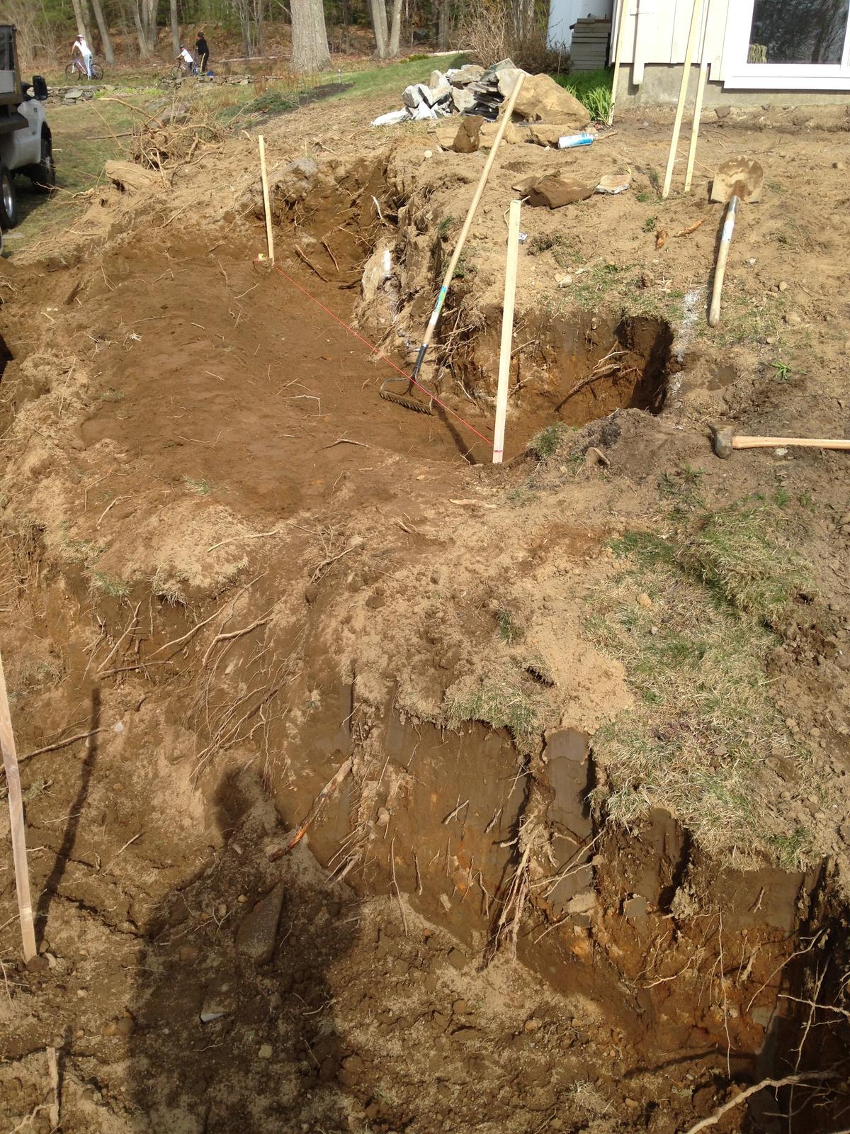 Excavated slope staked out for the new wall