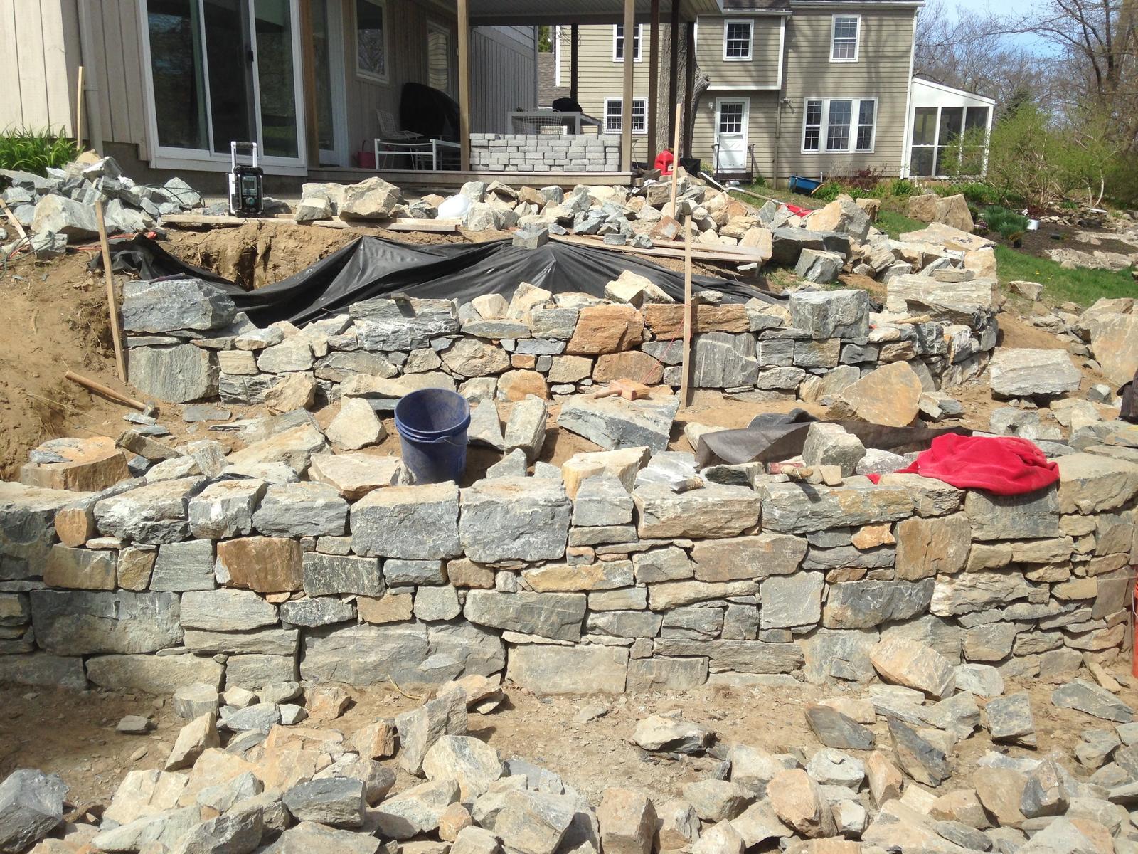 Stone wall taking shape along the excavated slope