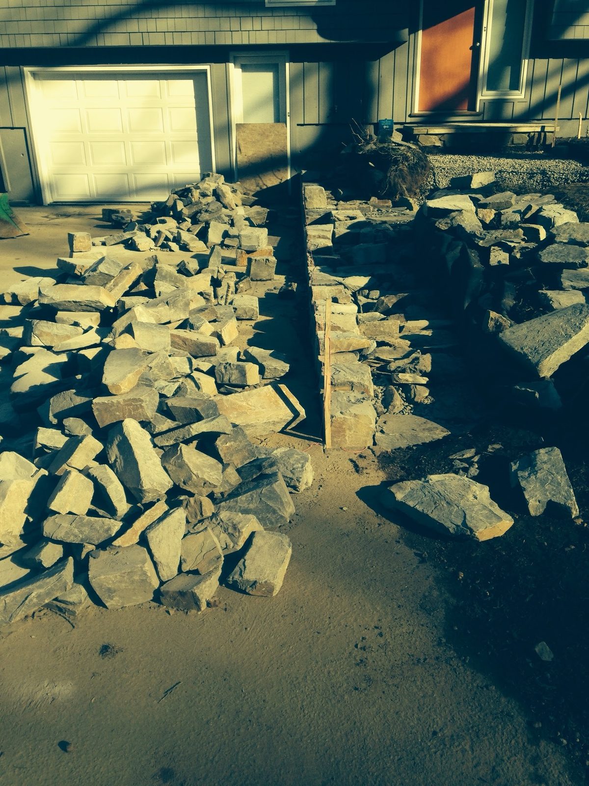 Cut stone staged beside the driveway before setting