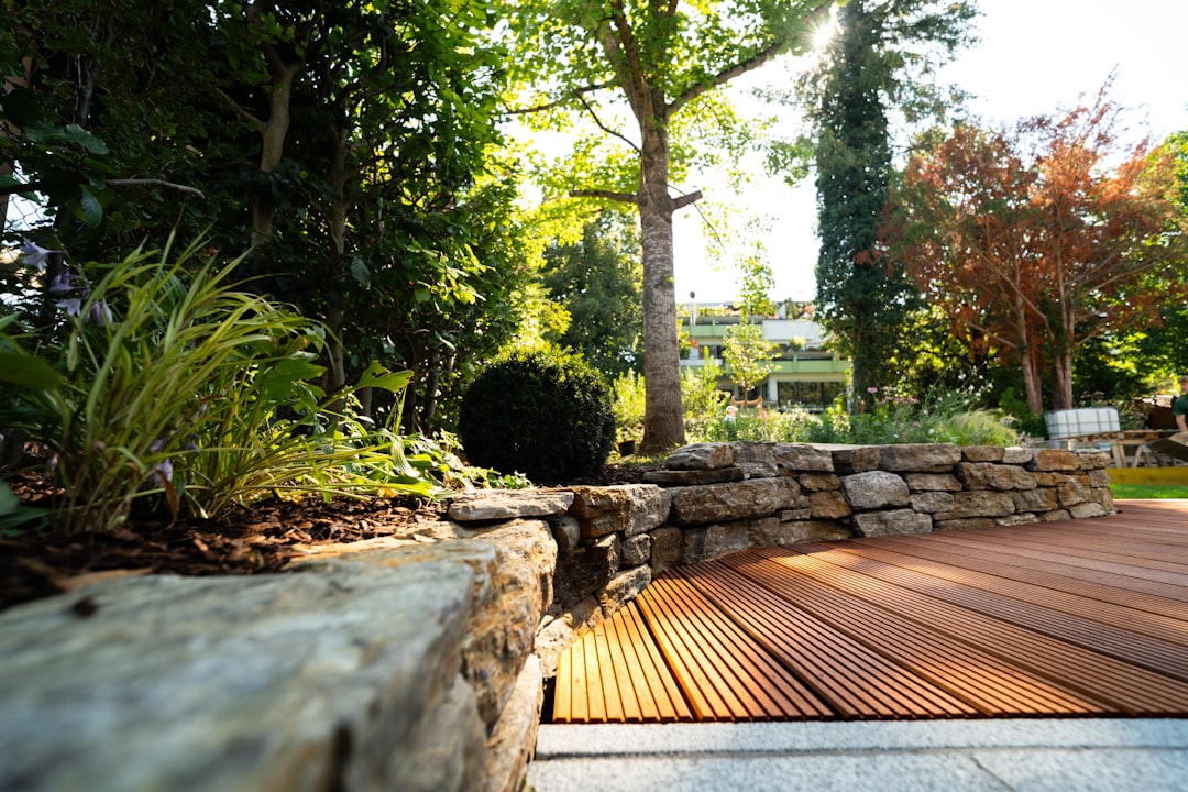 A patio made of Bangkirai wood and complemented with a natural stone wall. Shot in the warm summer months of Munich, Germany.